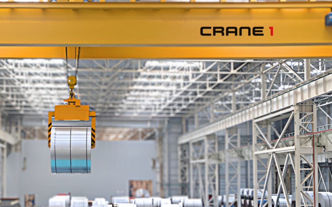 A yellow overhead crane labeled "CRANE 1" lifts a roll of sheet metal inside a spacious industrial warehouse.